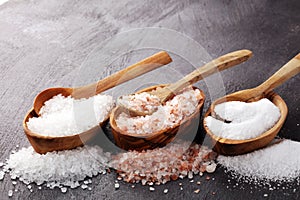 Sea salt and himalayan on spoon. Crystals of salt on background