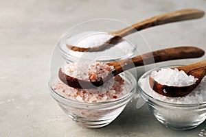 Sea salt and himalayan on spoon. Crystals of salt on background