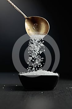 Sea salt is poured into a black bowl