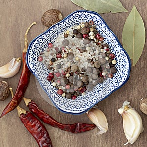 Sea salt and spices in small blue plate  chilli  Bay leaf  close-up  on wooden background