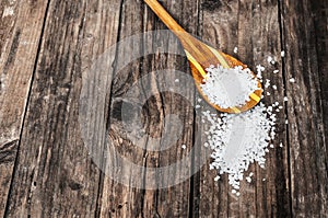 Sea salt in spoon on wooden table