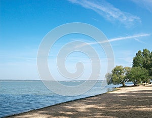 Sea sand beach bay blue water sky trees on the shore