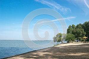 Sea sand beach bay blue water sky trees on the shore