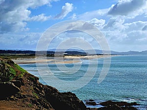 Sea, sand and beach seashore with endless horizon and lonely figures.