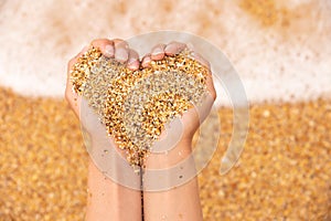 sea sand in the hands of man. heart shape. concept for sea, summer, vacation, travel