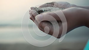 Sea sand running through a womans hands