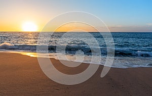 Sea sand and sky at sunset - horizontal background banner. Summer background with evening beach at sunset with waves, clouds -