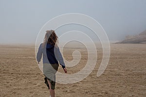 Sea and sandy beach in dense fog, autumn day