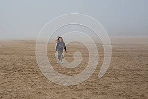 Sea and sandy beach in dense fog, autumn day