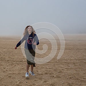 Sea and sandy beach in dense fog, autumn day