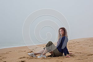 Sea and sandy beach in dense fog, autumn day