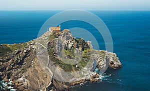 Sea scape on background gaztelugatxe steps sun huan, hipster girl looking on nature horizon ocean, relax holiday, blank space blue