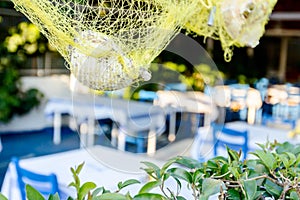 Sea shells with fishing net as artistic design in a typical outdoor Greek tavern