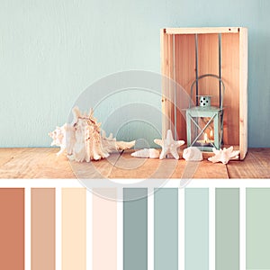 Sea shells and lantern on wooden table. vintage filtered image. nautical lifestyle concept. with palette color swatches