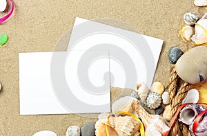 Sea shells with sand, rope and postcards as background