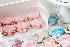 Sea shells shaped french macaroons in soft pastel pink and blue colors