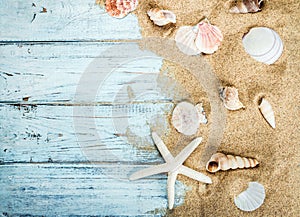 Sea shells and starfish on a blue wooden background and sand