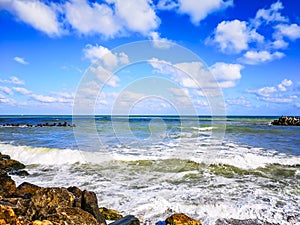 Sea shore with blue water, rocks and mistic summer sky