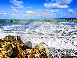 Sea shore with blue water, rocks and mistic summer sky