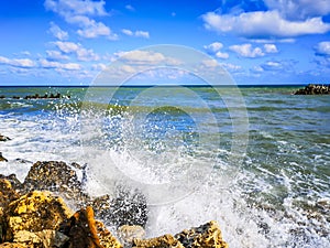 Sea shore with blue water, rocks and mistic summer sky