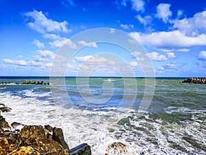 Sea shore with blue water, rocks and mistic summer sky