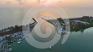 Sea shore inlet with white yachts sailing on colorful waves at sunset. North and South Jetty on Nokomis beach near