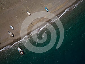 Sea shore, little fishing boats are parking at the beach, drone brids eye view, Sicily, Italy