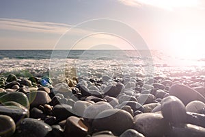 Sea shore with pebbles. wet sea pebbles on the beach and quiet sea surf