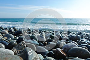 Sea shore with pebbles. wet sea pebbles on the beach and quiet sea surf