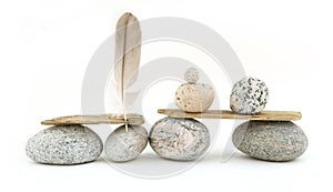 Sea smooth oval pebbles, driftwood and feather isolated on white background.