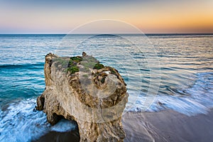 Sea stack and waves in the Pacific Ocean at sunset, seen from a