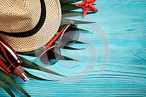 Sea stars, sea stones, palm leaves and shells lying on a blue wooden background . There is a place for labels.