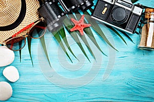 Sea stars, sea stones, palm leaves and shells lying on a blue wooden background . There is a place for labels.