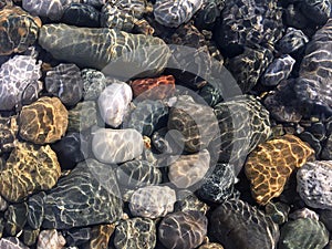 Sea stones in clean sea water. Pebbles under water