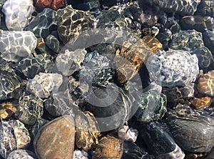 Sea stones in clean sea water. Pebbles under water