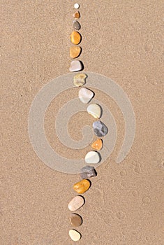 Sea stones on sand. Concept of skeleton, abnormal lateral curvature of spine