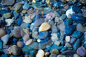 Sea stones in the sea water. Pebbles under water. The view from the top