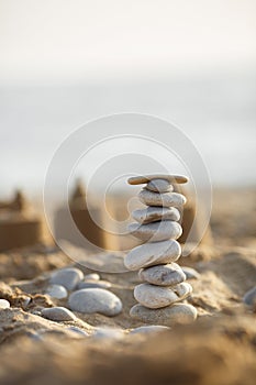 Sea stones tower on sand. summer and sunset on sea background. relaxation and meditation on beach