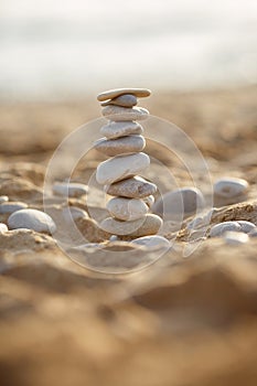 Sea stones tower on sand. summer and sunset on sea background. relaxation and meditation on beach