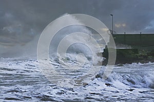 Sea storm waves crashing and splashing against jetty