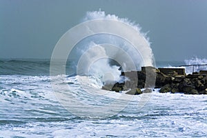 Sea storm waves crashing and splashing against jetty