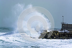 Sea storm waves crashing and splashing against jetty