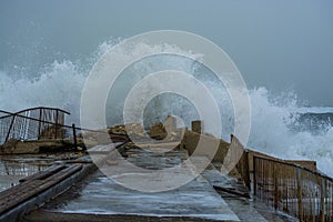 Sea storm waves crashing and splashing against jetty