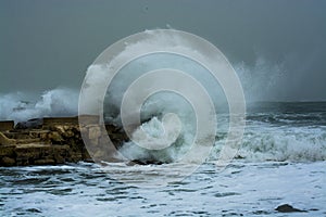 Sea storm waves crashing and splashing against jetty