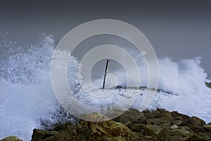 Sea storm waves dramatically crashing and splashing against rocks