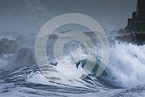 Sea storm waves dramatically crashing and splashing against rocks