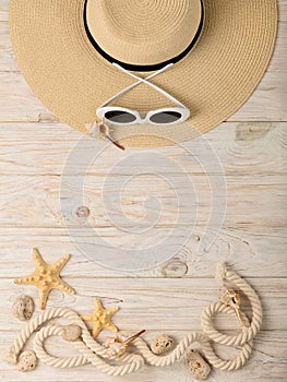 Sea style. Women`s accessories - sunglasses and hat on a wooden