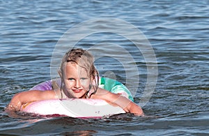 Sea, summer, child, girl, five-year-old, blonde, floats on an inflatable lifebuoy