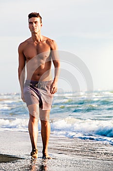 Sea in summer. Man walking on the shore.