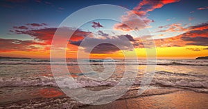 Sea sunrise with colorful cloudscape on sandy beach